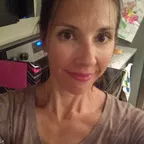 A woman in a casual indoor setting looking at the camera.