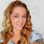 A smiling, healthy-looking woman representing the positive outcomes of a proactive wellness and fitness routine.