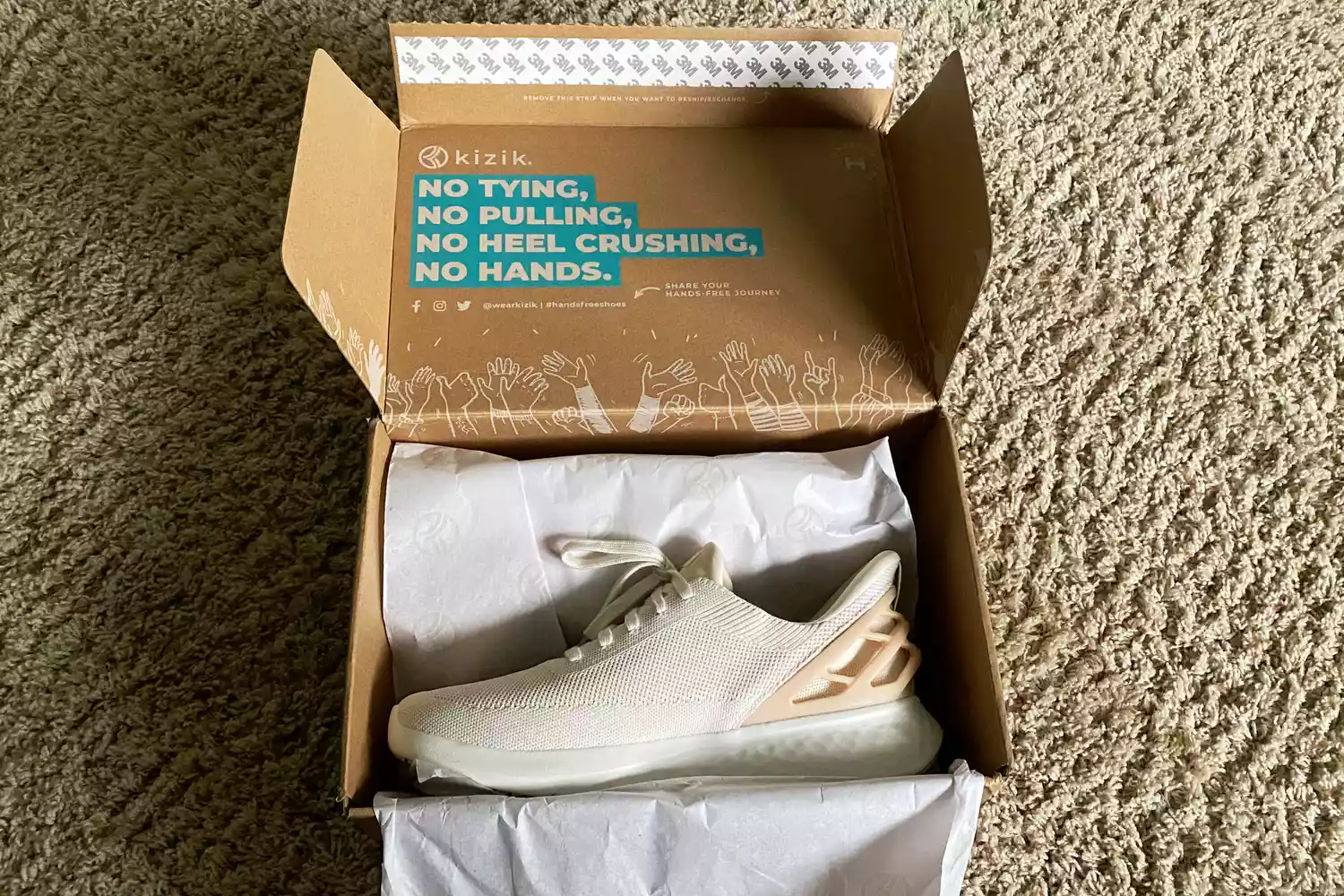 A Kizik hands-free sneaker inside its branded box.
