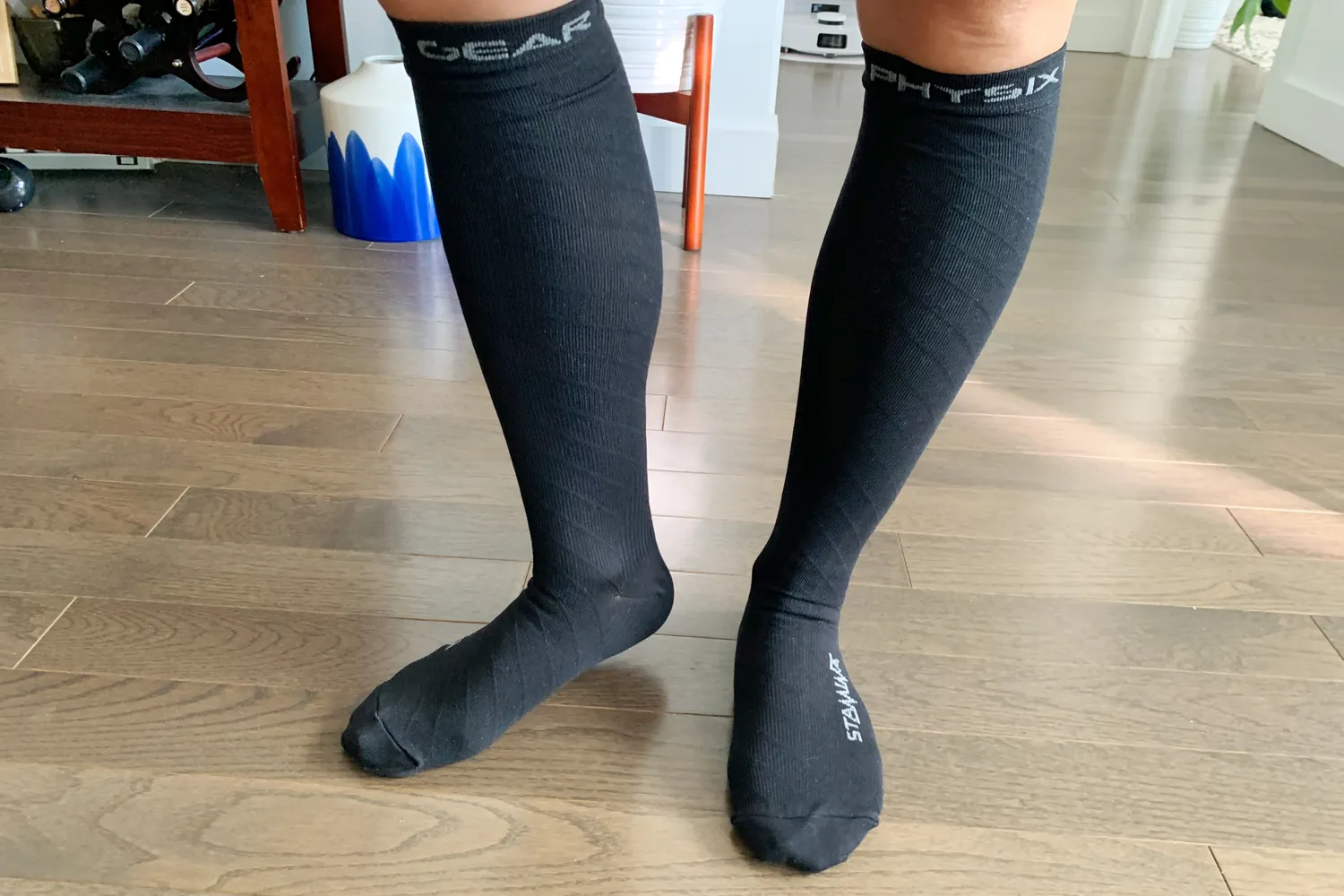 Tester wearing black Physix Gear compression socks in a home living room.