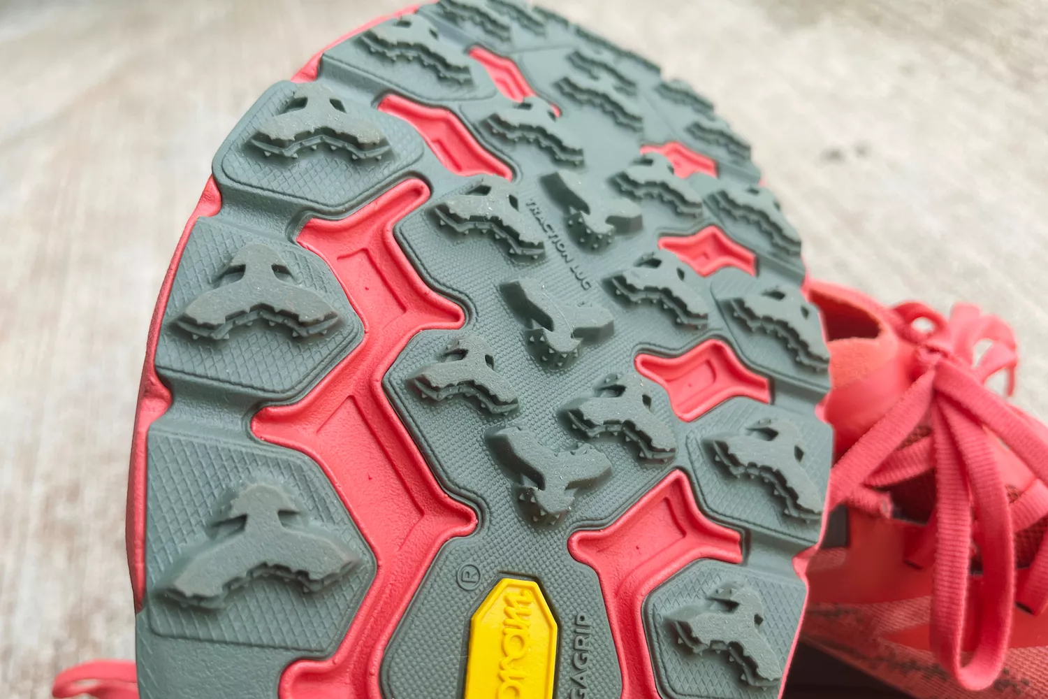 Close-up of a trail running shoe's outsole showing deep Vibram lugs for grip.