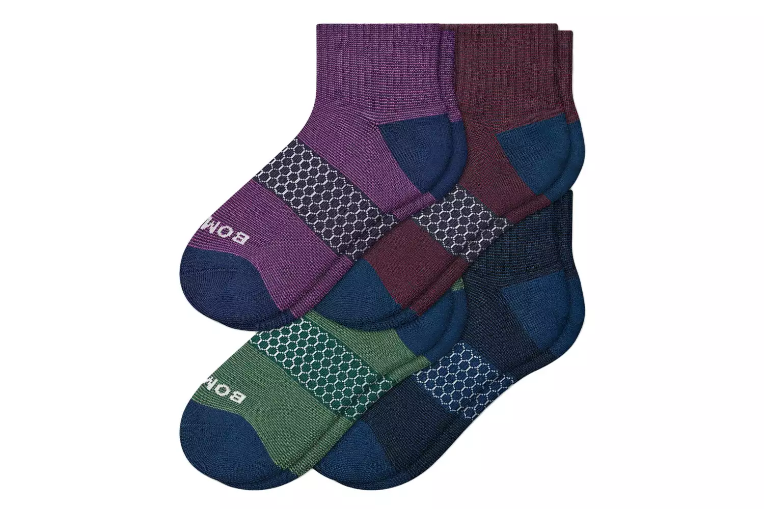 Three pairs of Bombas quarter-length socks in purple, burgundy, and green showing technical knit patterns.