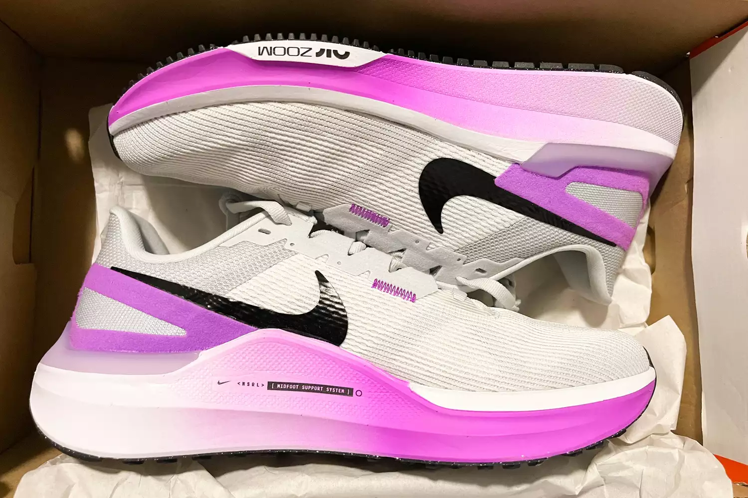 New Nike Air Zoom running shoes inside a product box.