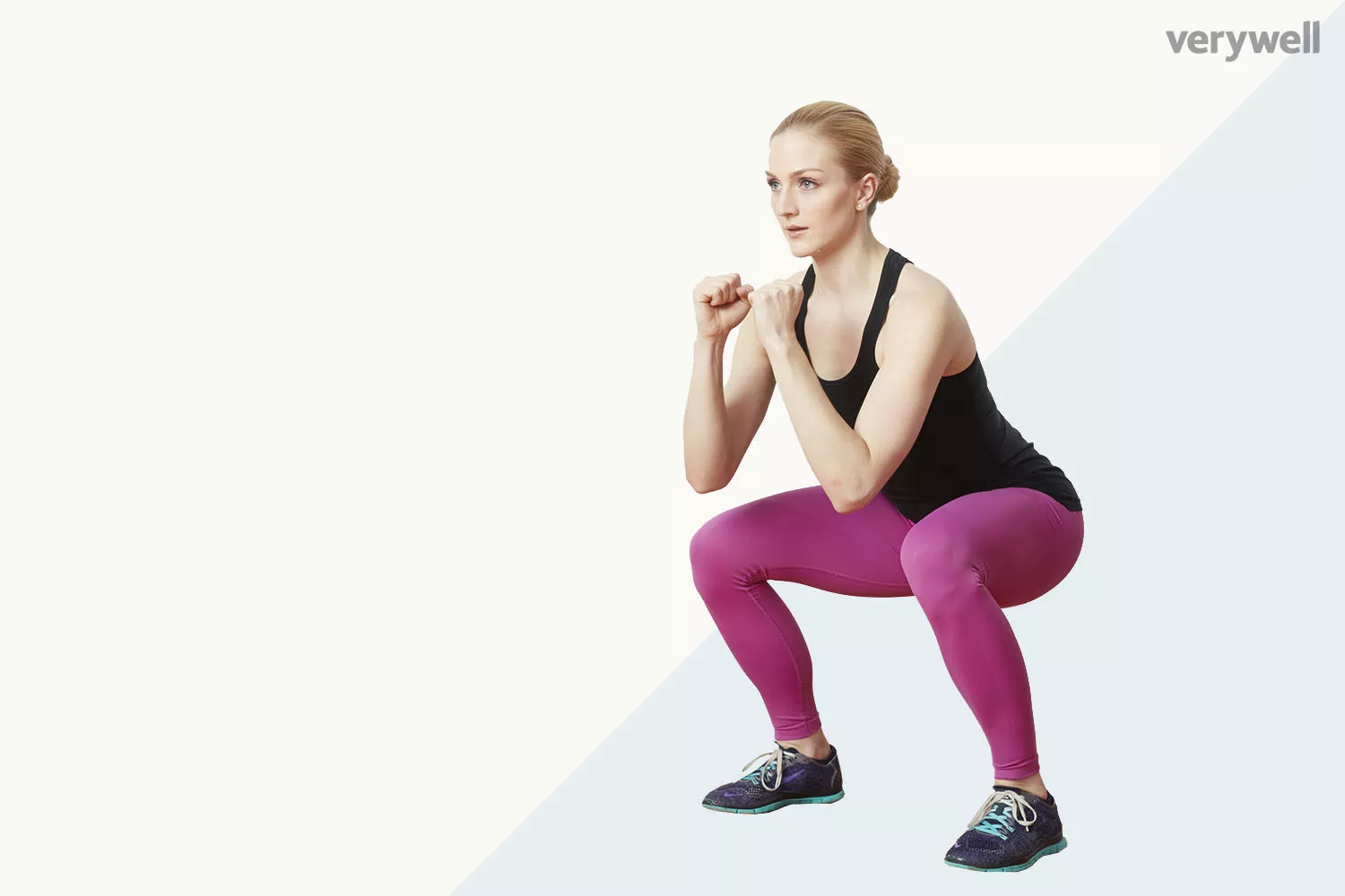 A woman performing a bodyweight squat with correct posture against a clean background.