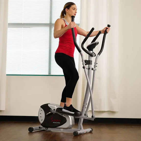A woman using a Sunny Health & Fitness elliptical machine in a home setting.