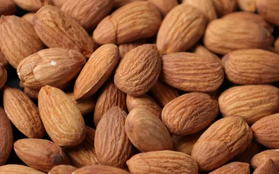 Close-up of raw, unshelled almonds.