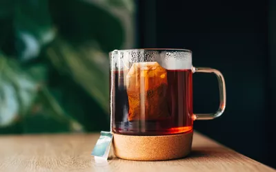 A glass teacup with steeping tea, representing a wellness ritual.