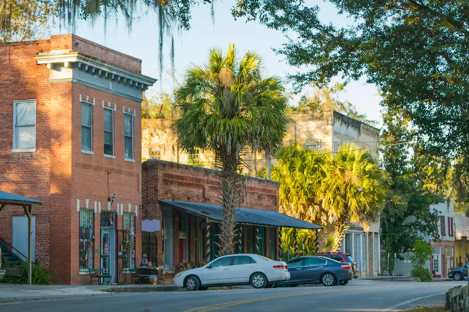 Historic downtown Micanopy featuring brick buildings and lush trees.