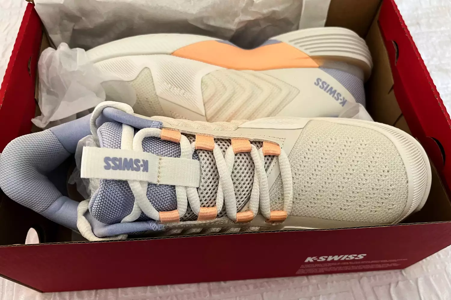 New K-Swiss Ultrashot 3 sneakers in a red box showcasing white and peach accents.