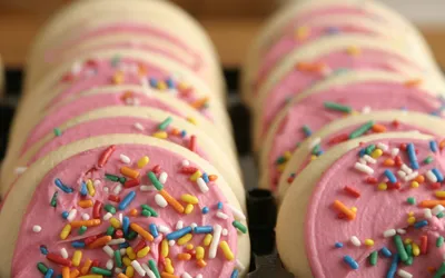 Close-up of pink frosted sugar cookies with sprinkles.