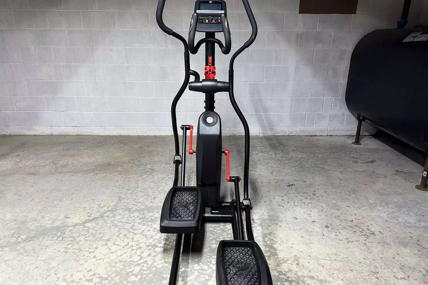 A Schwinn 411 Compact Elliptical Machine on a concrete floor in a home basement.