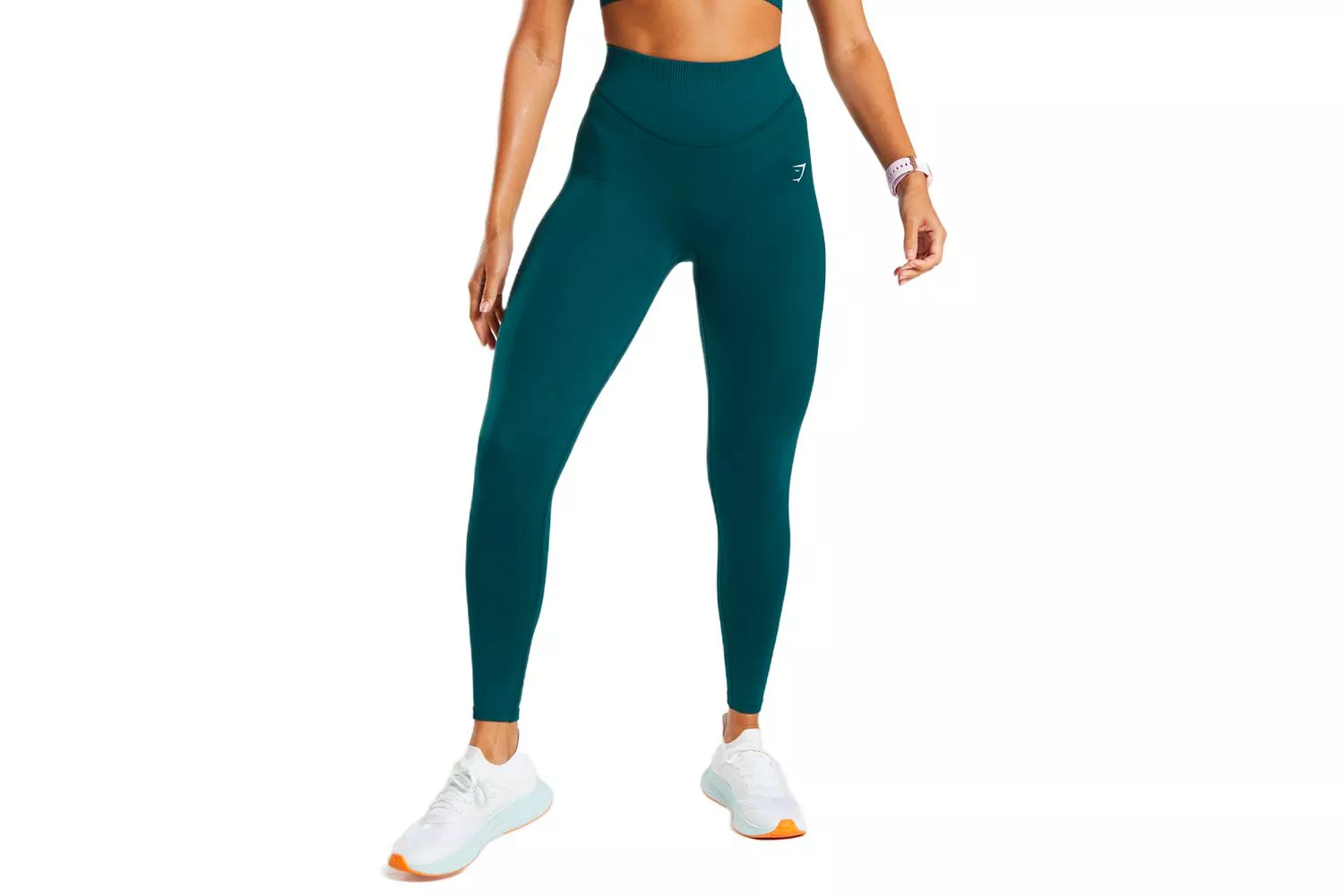 A woman wearing a teal high-waisted sports bra and leggings set.