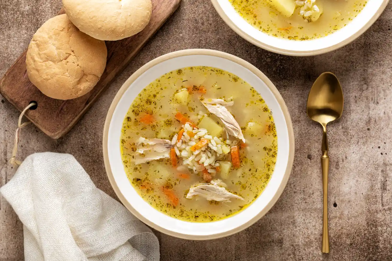 Top view of a homemade chicken and rice soup in a ceramic bowl.