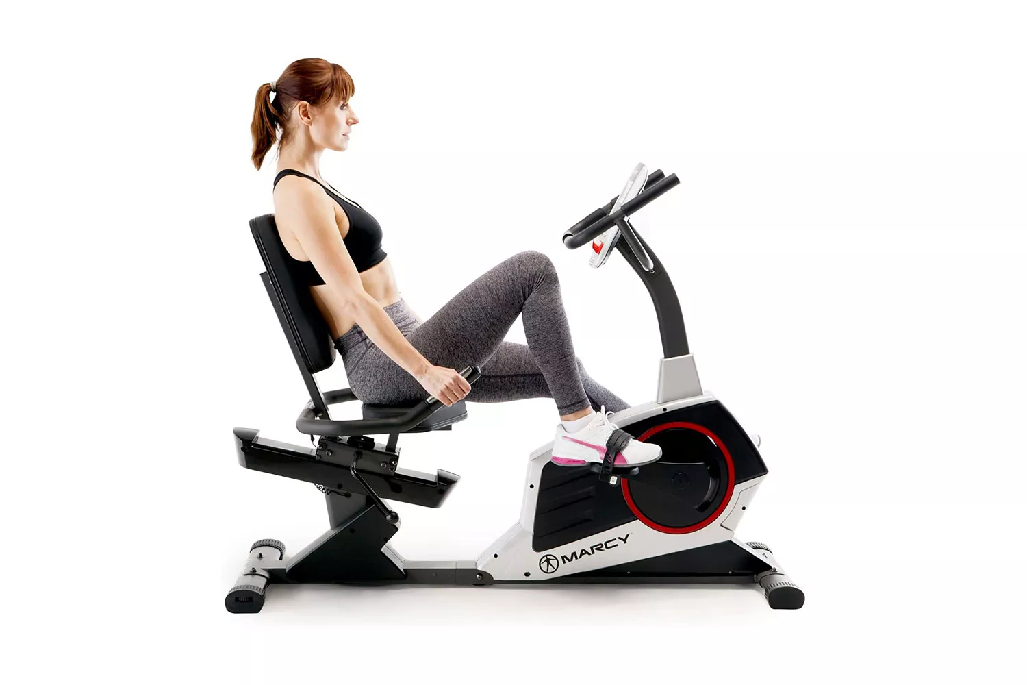 A woman exercising on a Marcy recumbent bike against a white background.