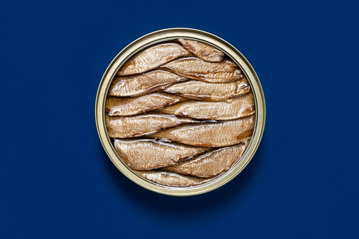 An open tin of canned sardines in oil.