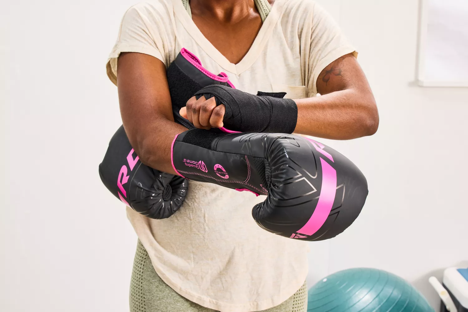 A person wrapping their hands with black athletic wraps before putting on gloves.