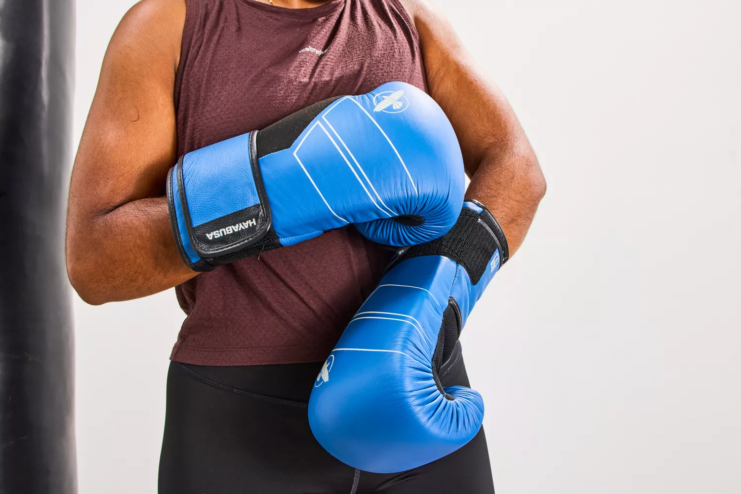 A close-up of blue Hayabusa S4 leather boxing gloves in a boxing stance.