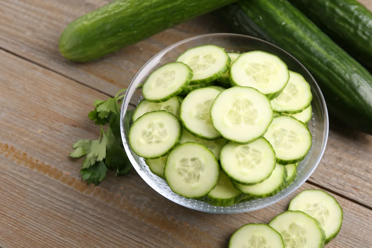 Slices of fresh green cucumber arranged on a surface.