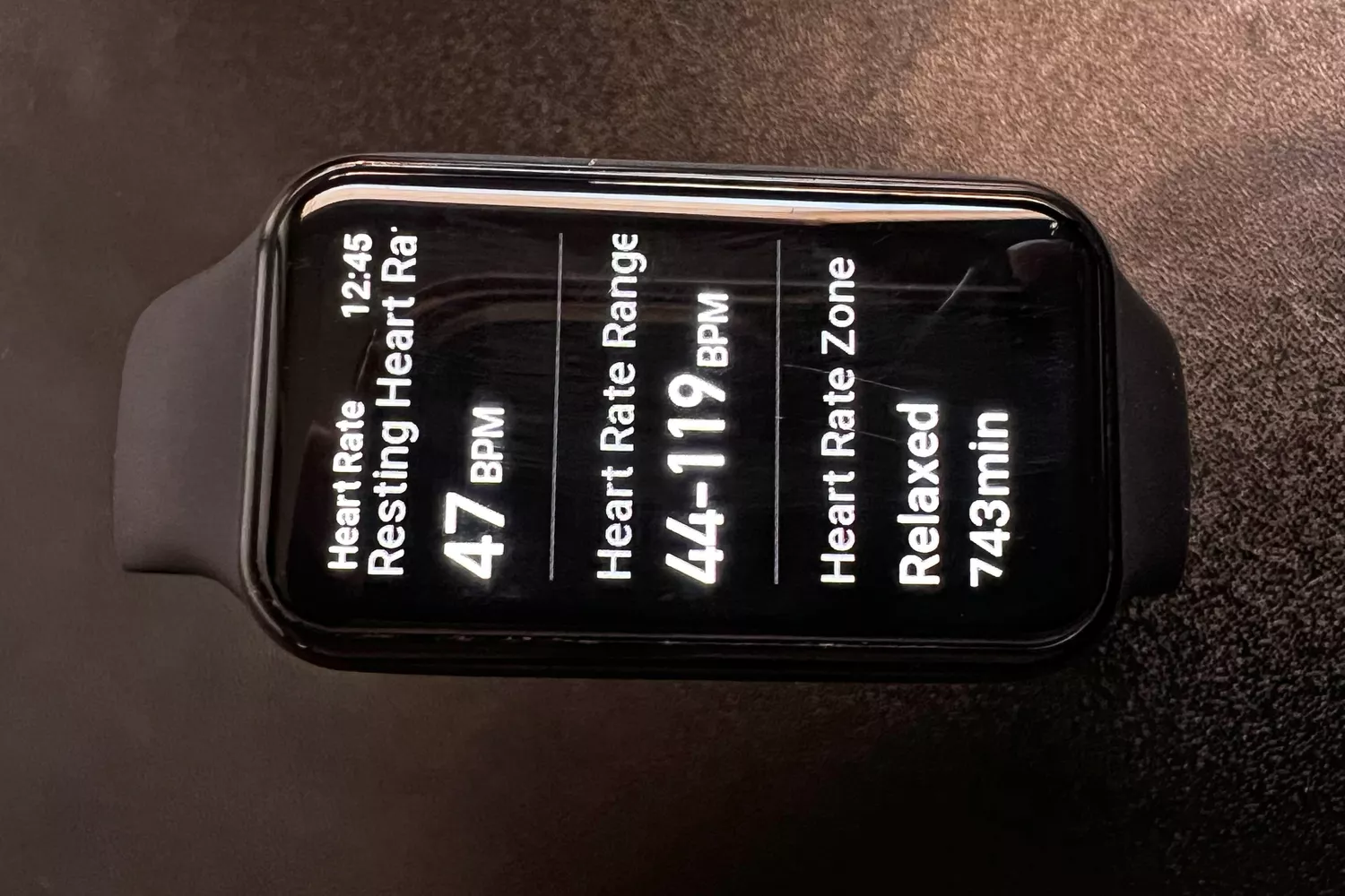 Smart fitness tracker screen displaying resting heart rate of 47 BPM and time spent in different heart rate zones.