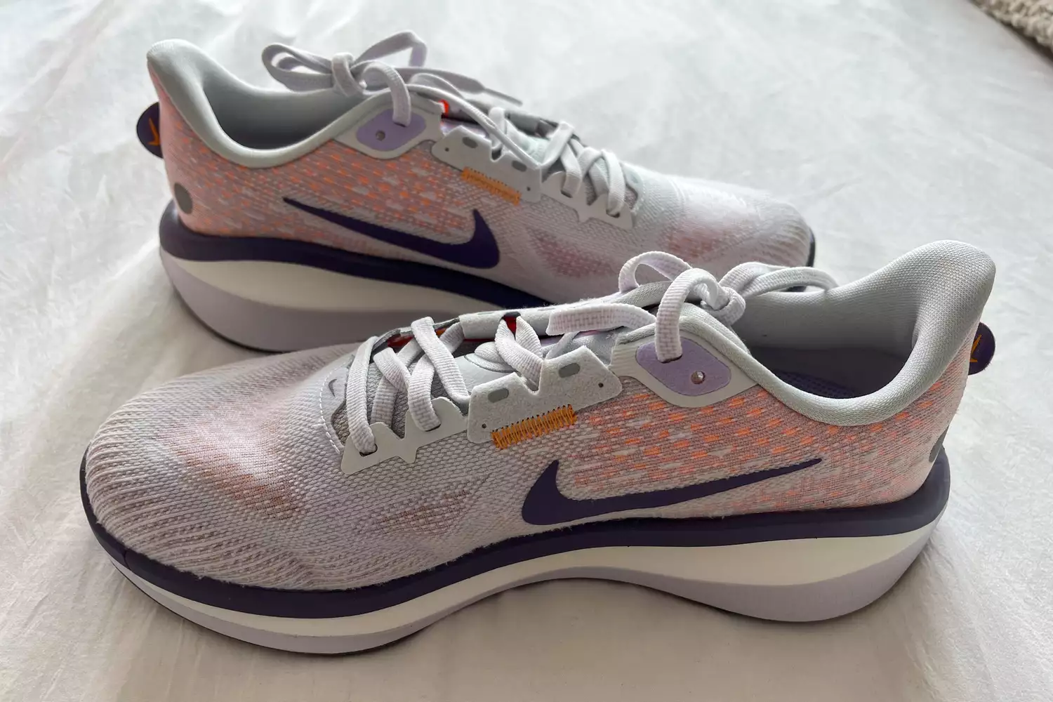 Nike Vomero 17 running shoes with white and orange knit upper.