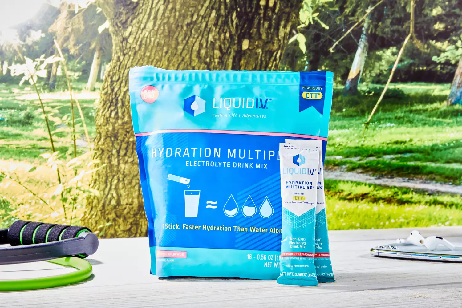 Liquid I.V. packets on a table with resistance bands and earbuds.