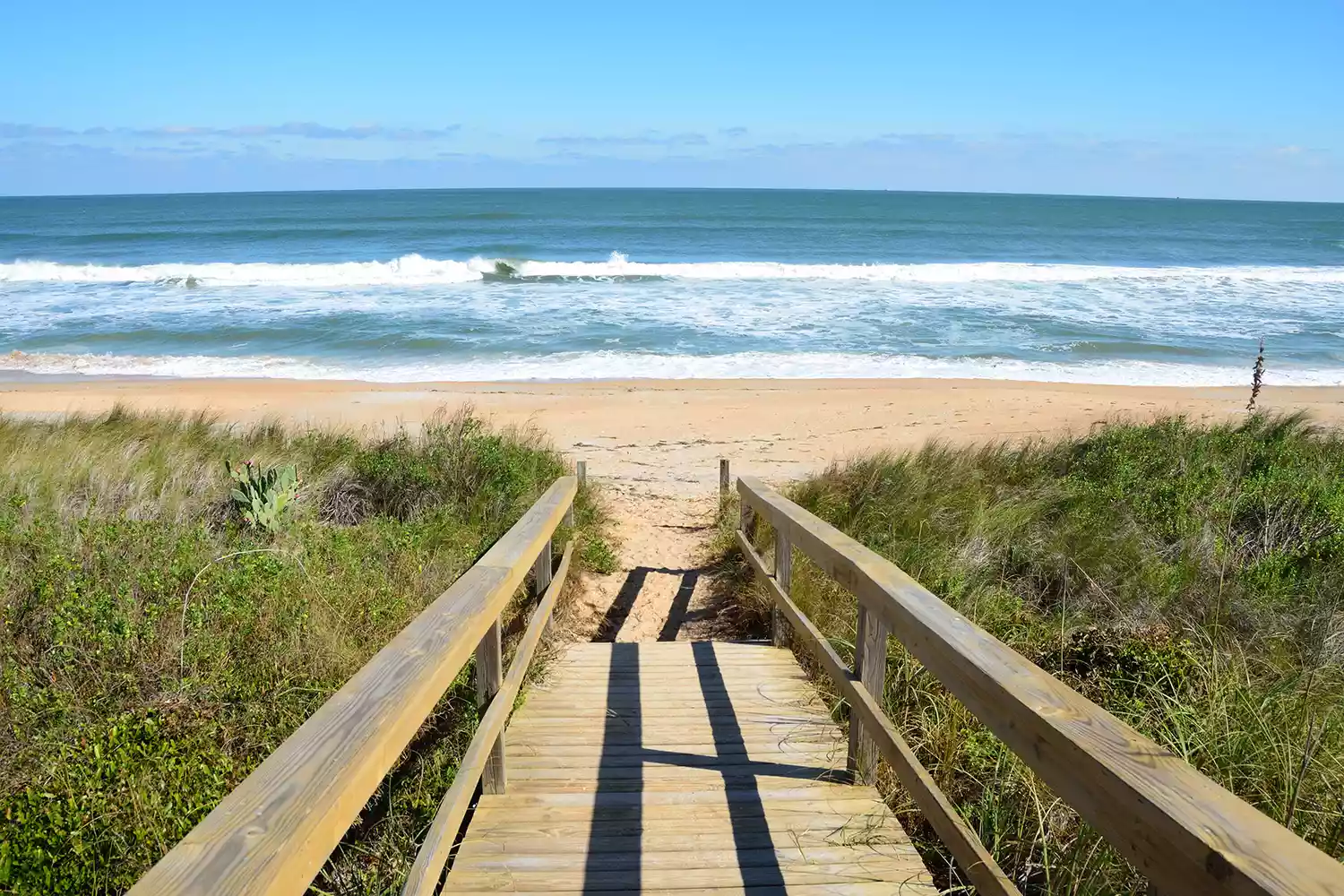 Wooden boardwalk leading to the dunes and sea in St. Augustine, Florida.