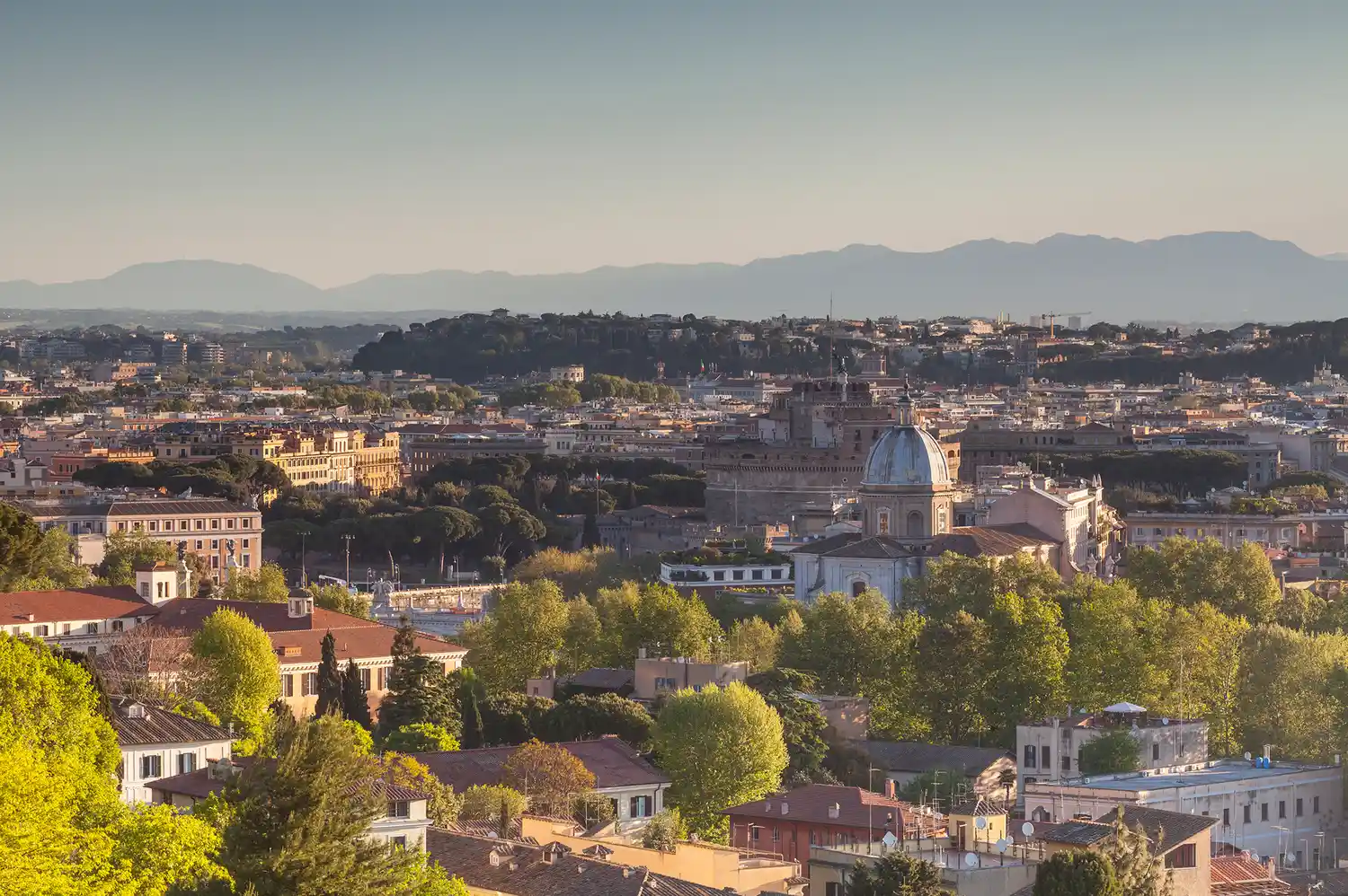 Panoramic view over the terracotta rooftops and domes of Rome from the Janiculum Hill vantage point.