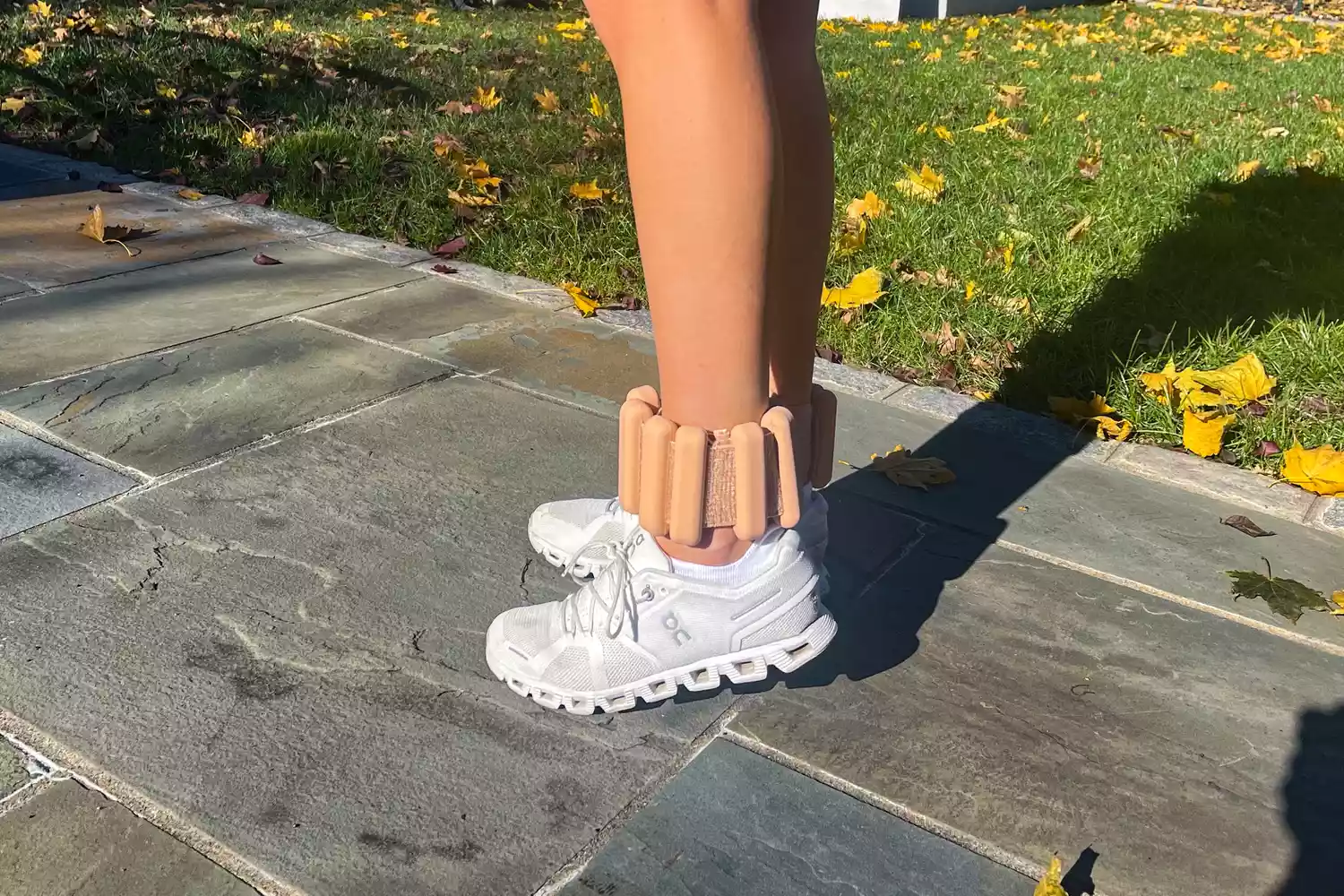 Person wearing Bala Bangles on their ankles while standing on a stone path outdoors.
